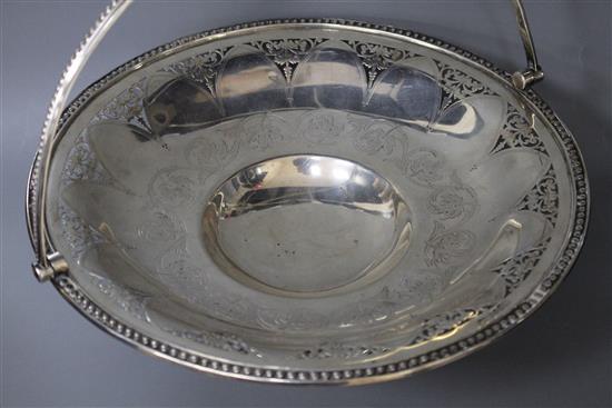 A Victorian engraved and pierced silver circular pedestal dish with swing handle, B.B, Sheffield, 1865,